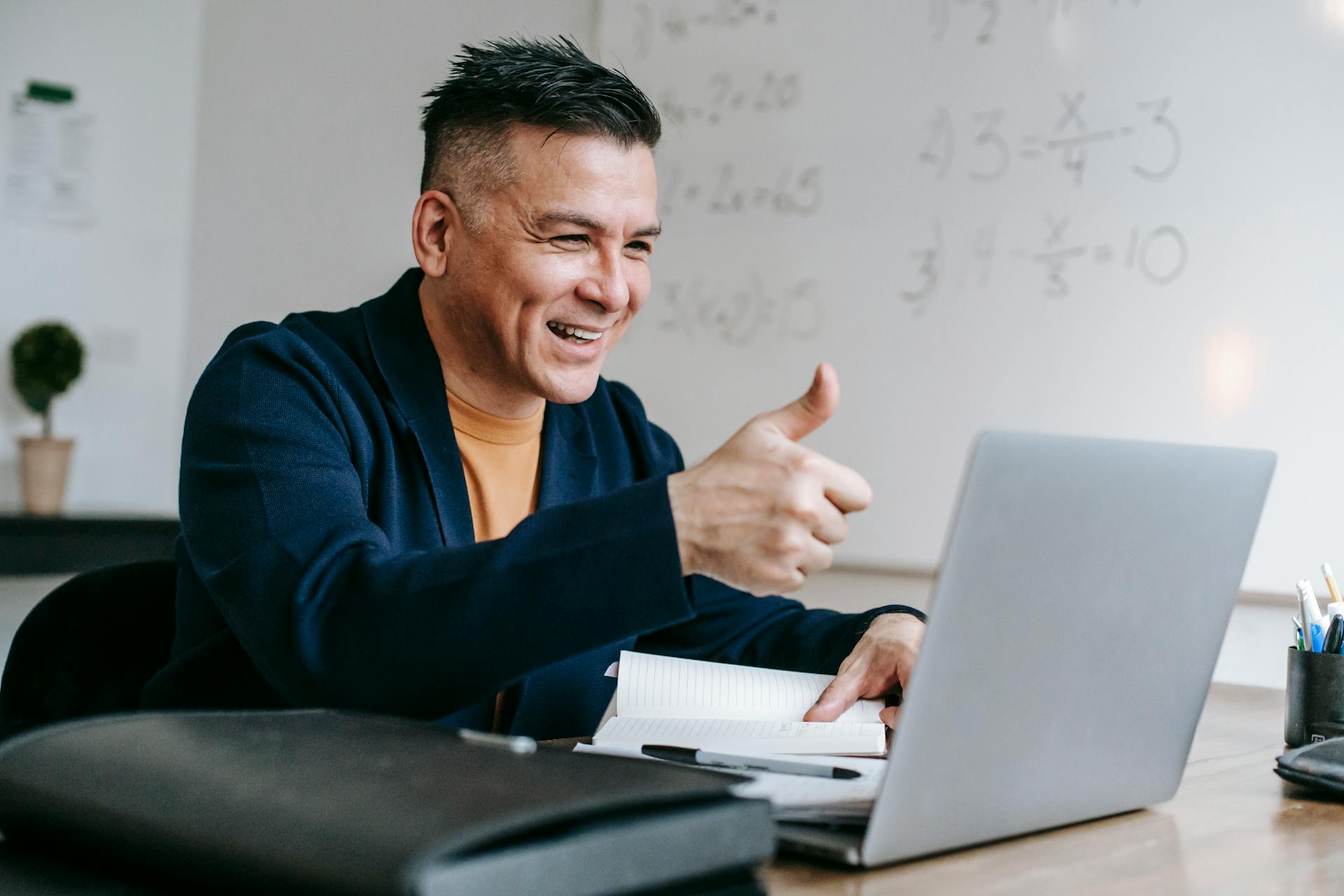 A man smile while holding his thumb up